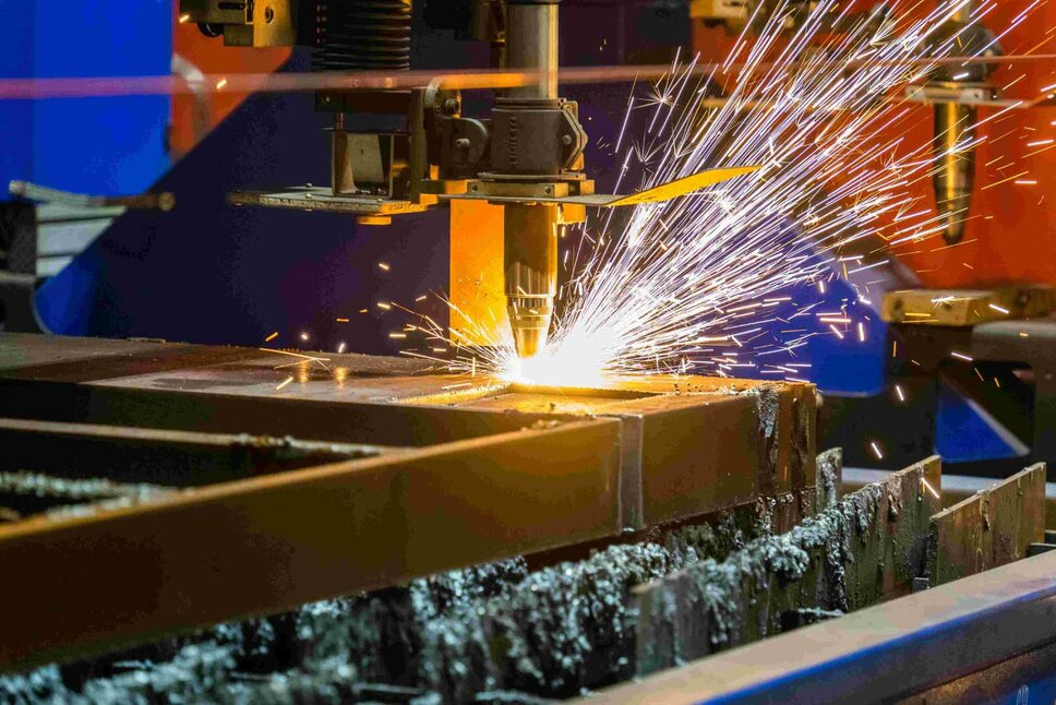 Eine industrielle Schweißmaschine erzeugt Funken, während sie Metallteile bearbeitet. Die Maschine führt präzises Punktschweißen durch, um Metallkomponenten zu verbinden. Im Hintergrund sind industrielle Geräte und eine leuchtende Arbeitsumgebung zu erkennen, während die Schweißmaschine in Aktion ist.