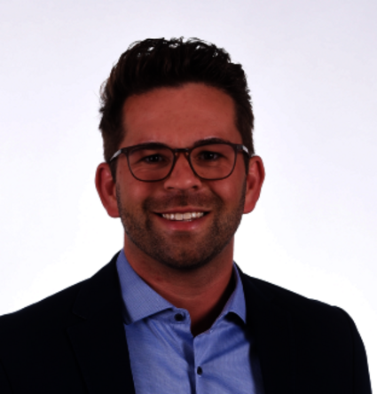 Mr. Faßbender, Sales Director at Gatzsch Schweißtechnik, is wearing a dark blue jacket and a light blue shirt. He has short brown hair, wears glasses with a subtle frame, and smiles warmly at the camera. The background of the image is solid white.